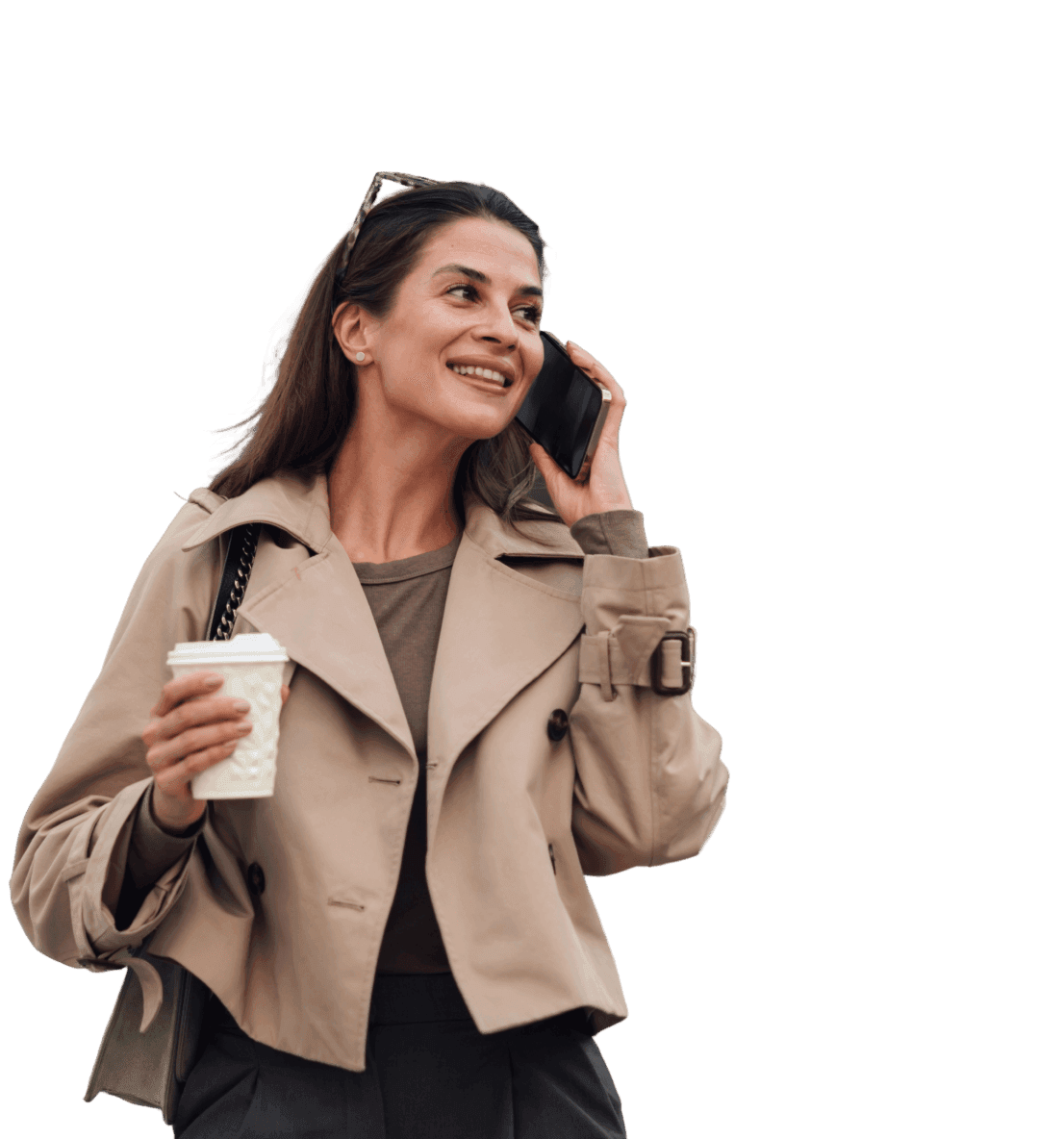 A woman wearing a trench coat talks on her phone, conveying a sense of urgency and professionalism.
