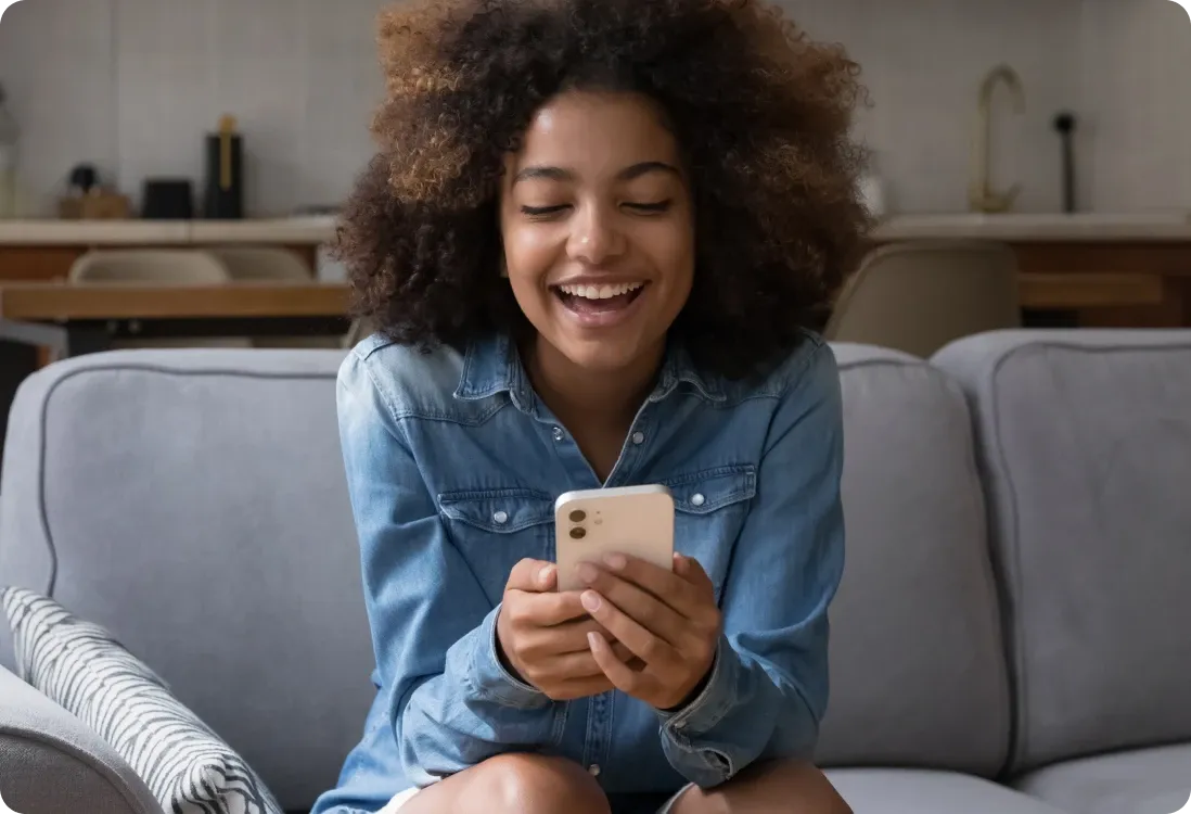 Woman sitting on sofa looking at phone